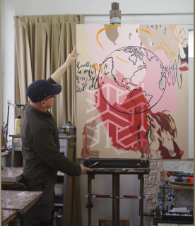 L'artiste nous présente sa toile dans son atelier.